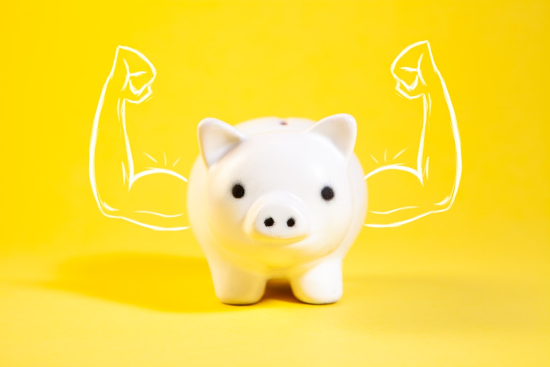 A white piggy bank with drawn muscular arms.