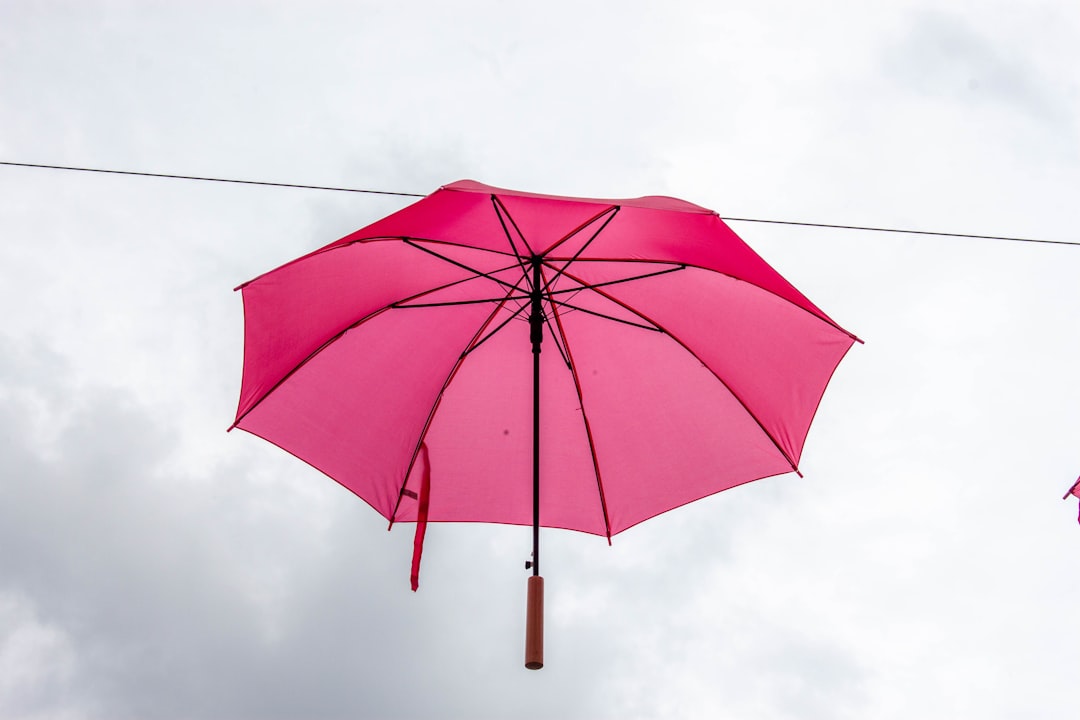 A bright pink umbrella suspended in the air.