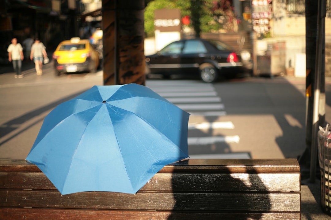 blue umbrella on sidewalk during daytime