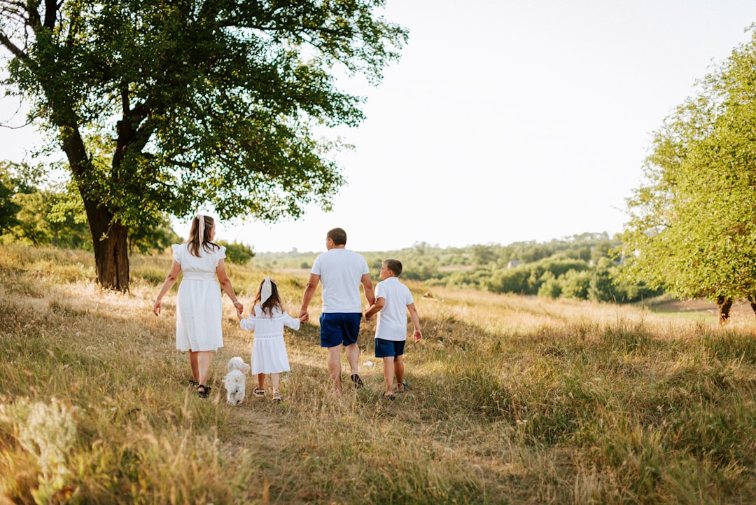 A family walking through a field with a dog
