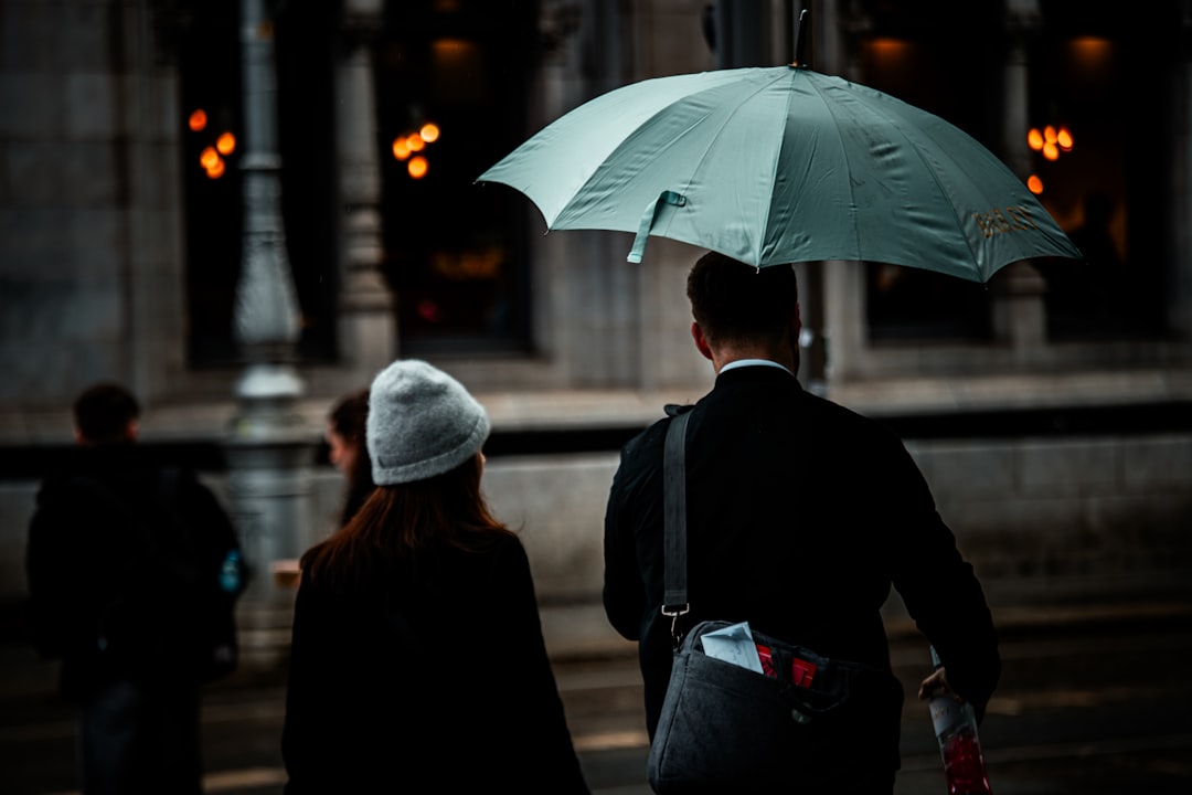 People walking under an umbrella on a rainy day.