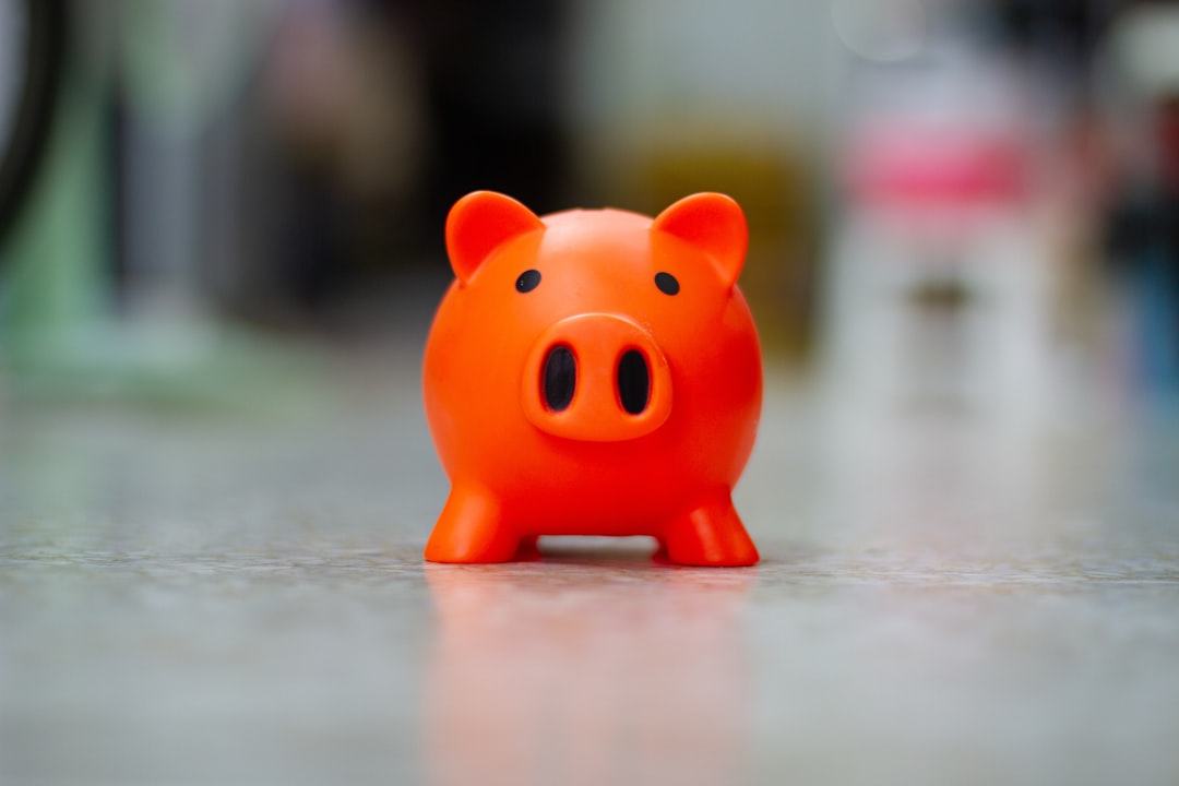 A small orange piggy bank sits on a surface.