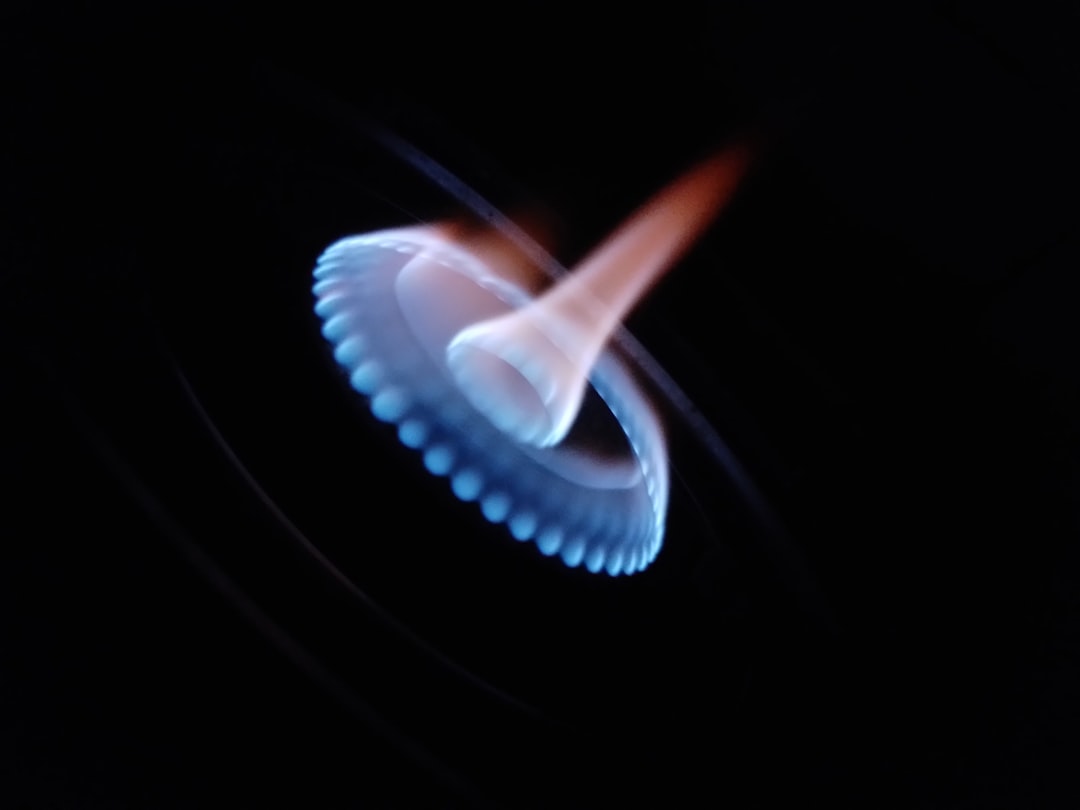 Blue gas flame with orange glow on black background
