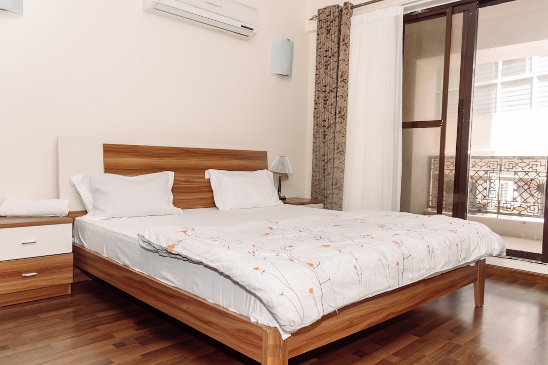 a bed sitting in a bedroom next to a window