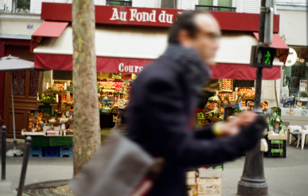 Man walking past a storefront in paris