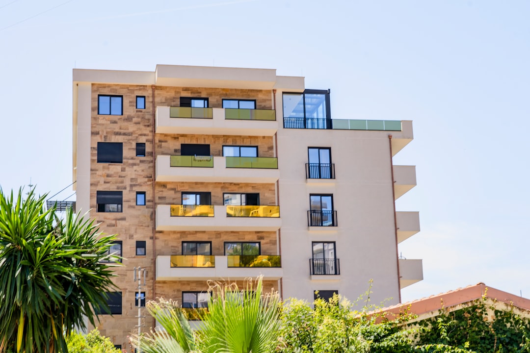 a tall building with lots of windows next to trees