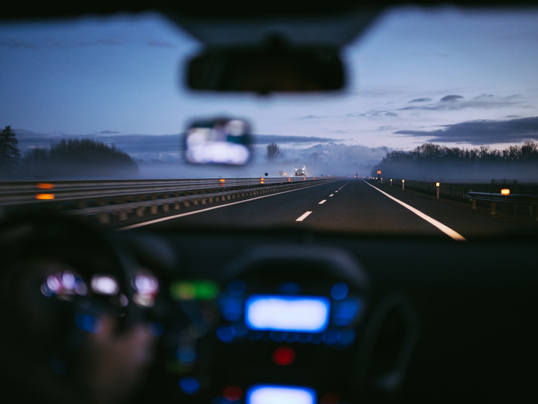 A view from inside a car driving on a misty highway at night
